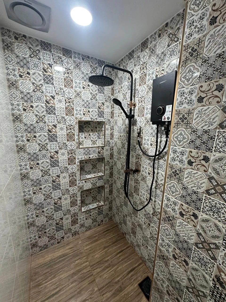 Finished tiled shower area with fitted fixtures
